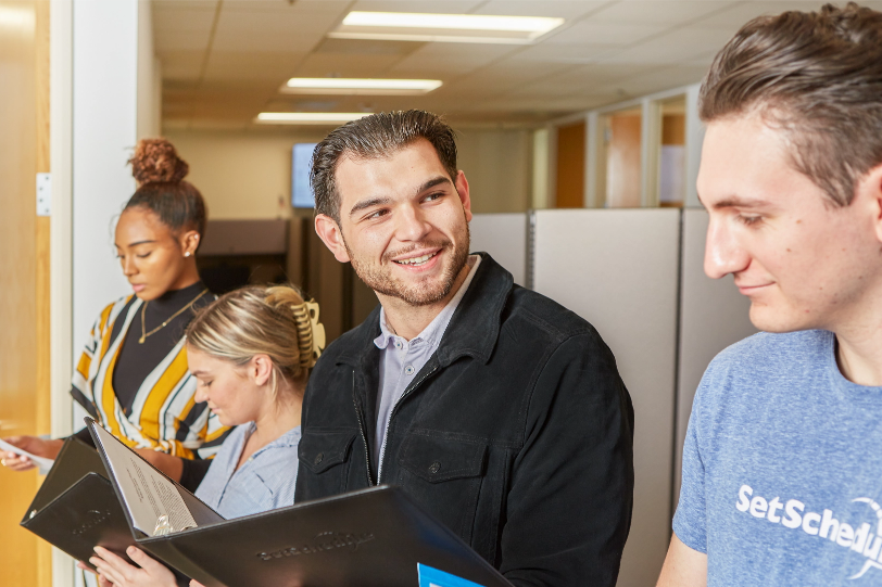 Four SetSchedule employees networking with each other