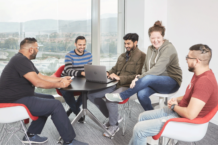 Five SetSchedule team members collaborating with a laptop