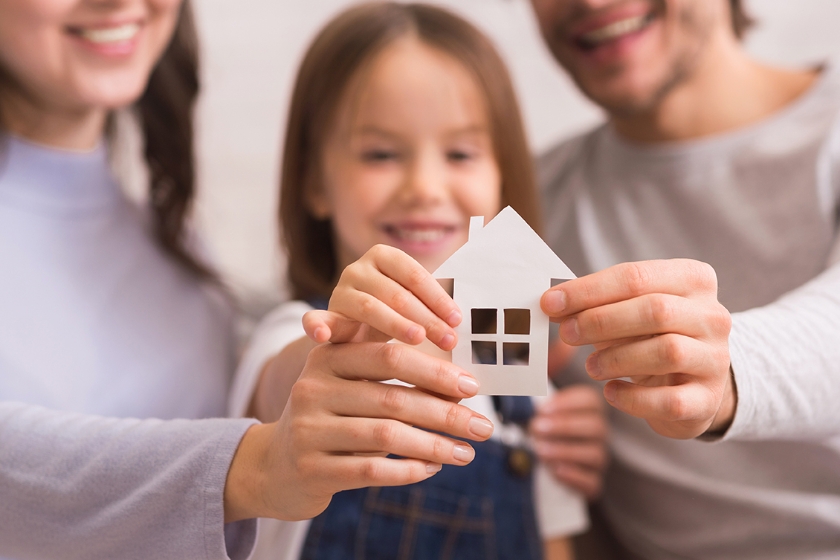 Family holding a paper house